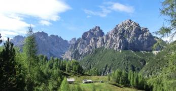 Il ripiano prativo di Casera Valbinon. Sullo sfondo, la Cima dei Pecoli, la Cima Urtisiel Ovest e gli Spalti di Toro