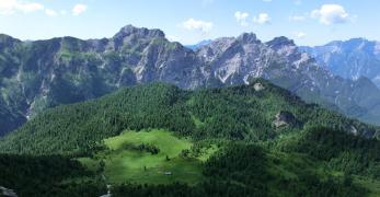 Il pianoro di Casera Bregolina Grande con il Col de le Ortige e il Monte Bregolina. Sullo sfondo, il Monte Turlon e il Gruppo della Vacalizza
