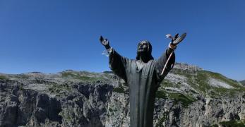 Il Cristo in bronzo sulla Prima Pala di San Lucano. Sullo sfondo, il Monte San Lucano