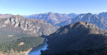 La conca del Palughet fra cima Saline e le Cime di Caiada. Sullo sfondo, le Dolomiti d’Oltrepiave