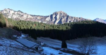 La conca del Palughet con l’omonima casera. Sullo sfondo, le Cime di Caiada